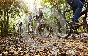 Group of friends ride mountain bike in the forest together photo