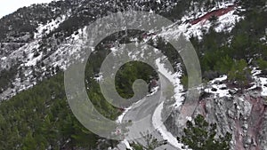 Group of friends riding bicycles on mountain switchbacks. Cyclists cycling road bikes through snowy mountain hills. Cycling sport