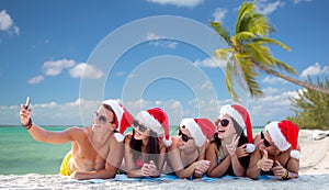 Group of friends in santa hats with smartphone