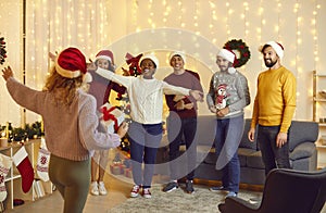 Group of friends in santa hats welcoming their female friend at Christmas party at home.