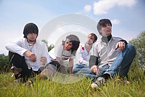 Group of friends sit on grass