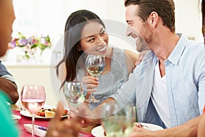 Group Of Friends Sitting Around Table Having Dinner Party