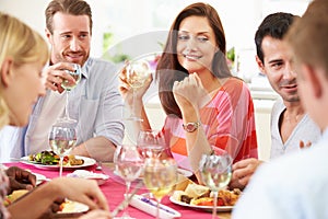 Group Of Friends Sitting Around Table Having Dinner Party