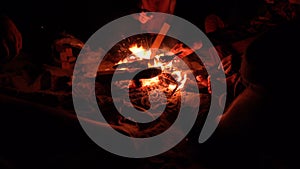 Group of Friends Sitting near Campfire at Night ocean beach and Hanging Out. 4K UHD .