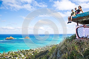 A group of friends sitting on pillbox over looking Lanikai in Kailua Hawaii