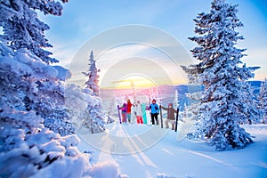 Group friends with ski and snowboard on winter holidays. Skiers having fun on forest snow Sunrise blue sky on top of