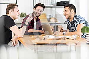Group of friends smiling and looking at a token in a an office