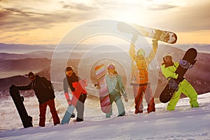 Group of friends snowboarders having fun on the top of mountain