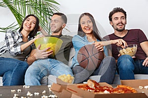 Group of friends sport fans watching basketball game eating snacks