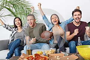 Group of friends sport fans watching rugby match cheering team