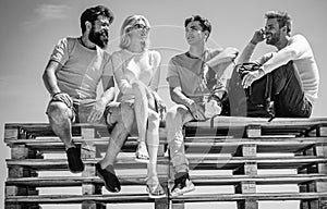 Group of friends students having break and chating together sitting at clear sky background. Friendship and studentship