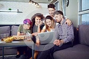 A group of friends of students in leisure with a laptop in a roo