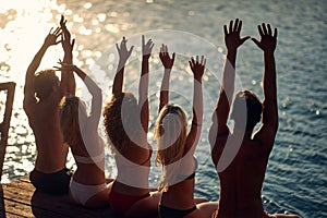 Group of friends sunbathing on the summer day on the lake