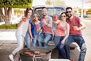 Group of friends tailgating and grilling burgers photo