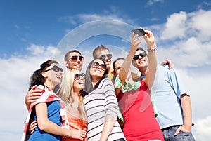 Group of friends taking picture with smartphone