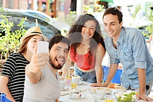 Group of friends taking selfie in cafe