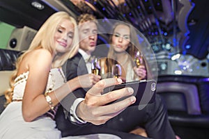 Group of friends taking a selfie in limousine