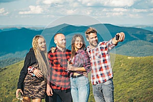 Group of friends taking a selfie in the mountains. Group of hikers takes photo in nature. Camping together is fun