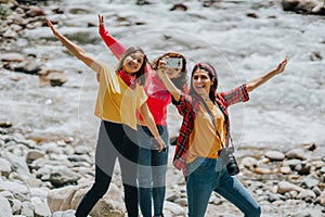 Group of friends taking selfie near the stream