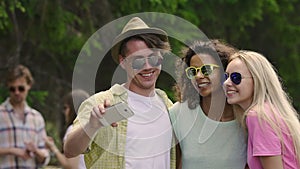 Group of friends taking selfie at party, young people having fun outdoors