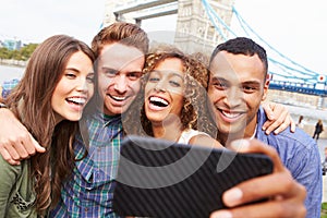 Group Of Friends Taking Selfie By Tower Bridge In London