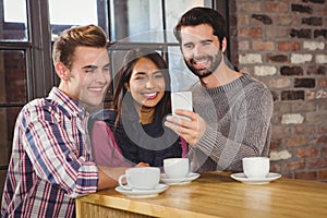 Group of friends taking selfies with a smartphone