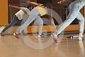 Group of friends throwing balls in bowling