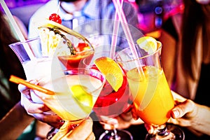 Group of friends toasting cocktail at bar counter