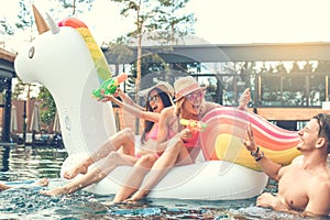 Group of friends together in the swimming pool leisure