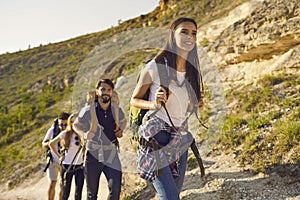 Group of friends tourists with backpacks traveler in the mountains on a hike hiking along the route in nature in summer.