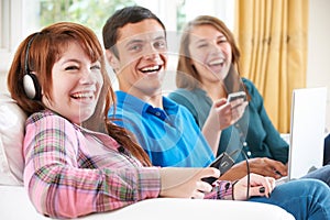 Group Of Friends Using Digital Technology At Home