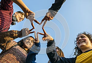 Group of friends using fingers to form the star shape teamwork and support concept