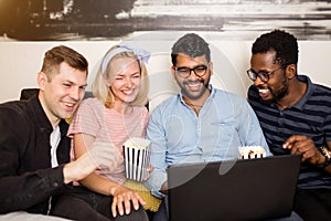 A group of friends using laptop and laughing