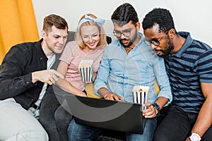 A group of friends using laptop and laughing