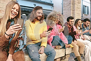 Group friends using mobile smartphone outdoor - Trendy young people having fun with new technology apps for social media phone