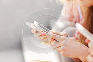Group of friends using smartphones in the city
