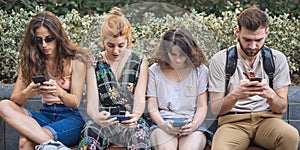 Group of friends using smartphones. Emotional isolation and technology depresion photo