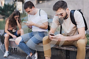 Group of friends using smartphones. Emotional isolation and technology depresion photo