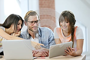 Group of friends using tablet and laptop