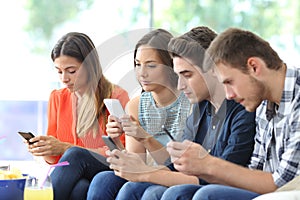 Group of friends using their smart phones at home