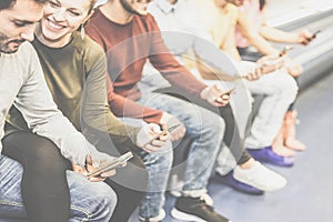 Group of friends using together their mobile smart phones while sitting in underground - Young people surfing on social network