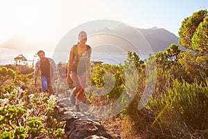 Group Of Friends Walking Along Coastal Path Together