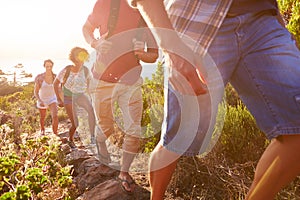 Group Of Friends Walking Along Coastal Path Together