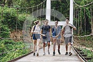 Group of friends walking on the bridge in a tropical countryside adventure and journey concept