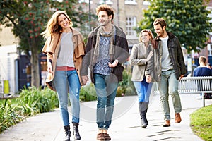 Group Of Friends Walking Through City Park Together