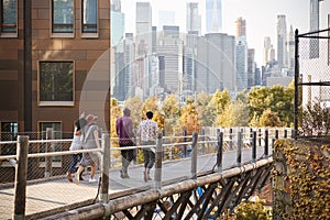 Group Of Friends Walking With Manhattan Skyline In Background