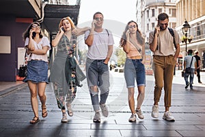 Group of friends walking and talking in the city center