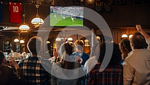 Group of Friends Watching a Live Soccer Match on TV in a Sports Bar. Excited Fans Cheering and