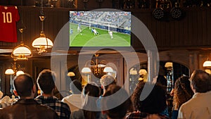Group of Friends Watching a Live Soccer Match on TV in a Sports Bar. Excited Fans Cheering and