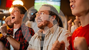 Group of Friends Watching a Live Soccer Match on TV in a Sports Bar. Happy Fans Cheering and